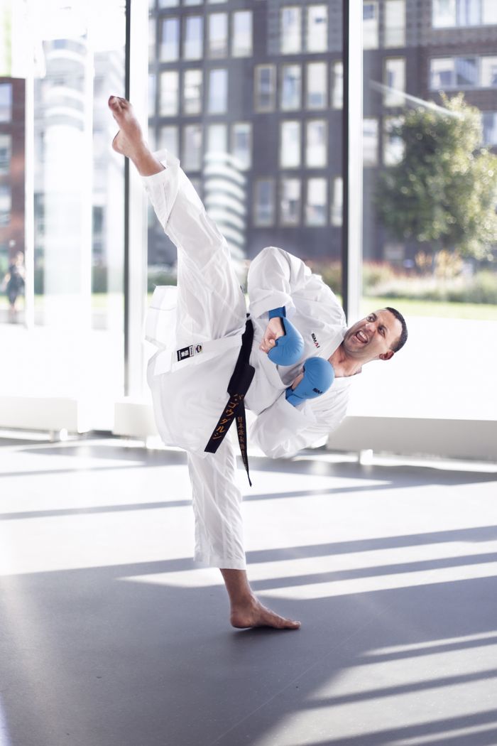 The Art of Drawing Readers In: Your attractive post title goes here Martial artist in sportswear executing a high kick in a sunlit indoor space.