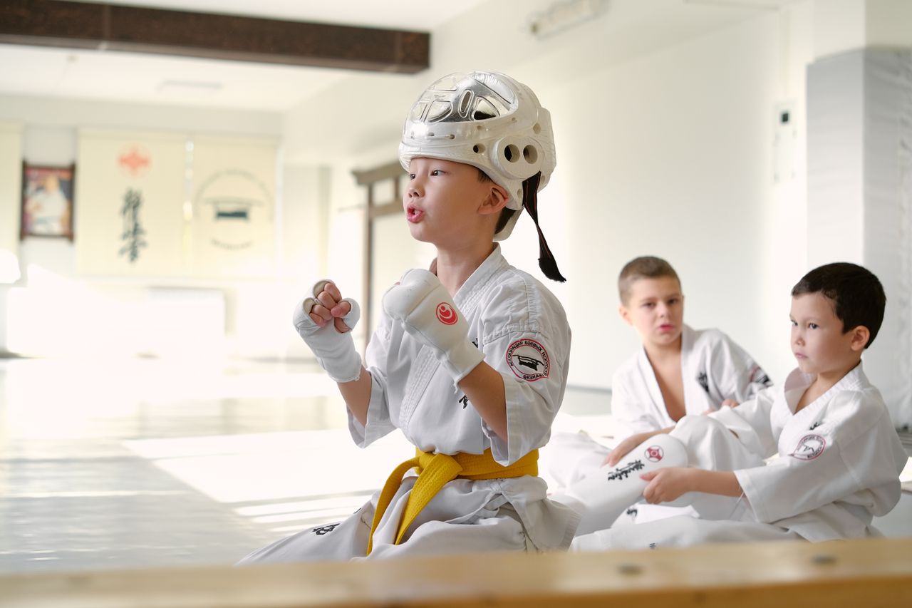 Young martial arts students in kimonos train together indoors, focusing on techniques.