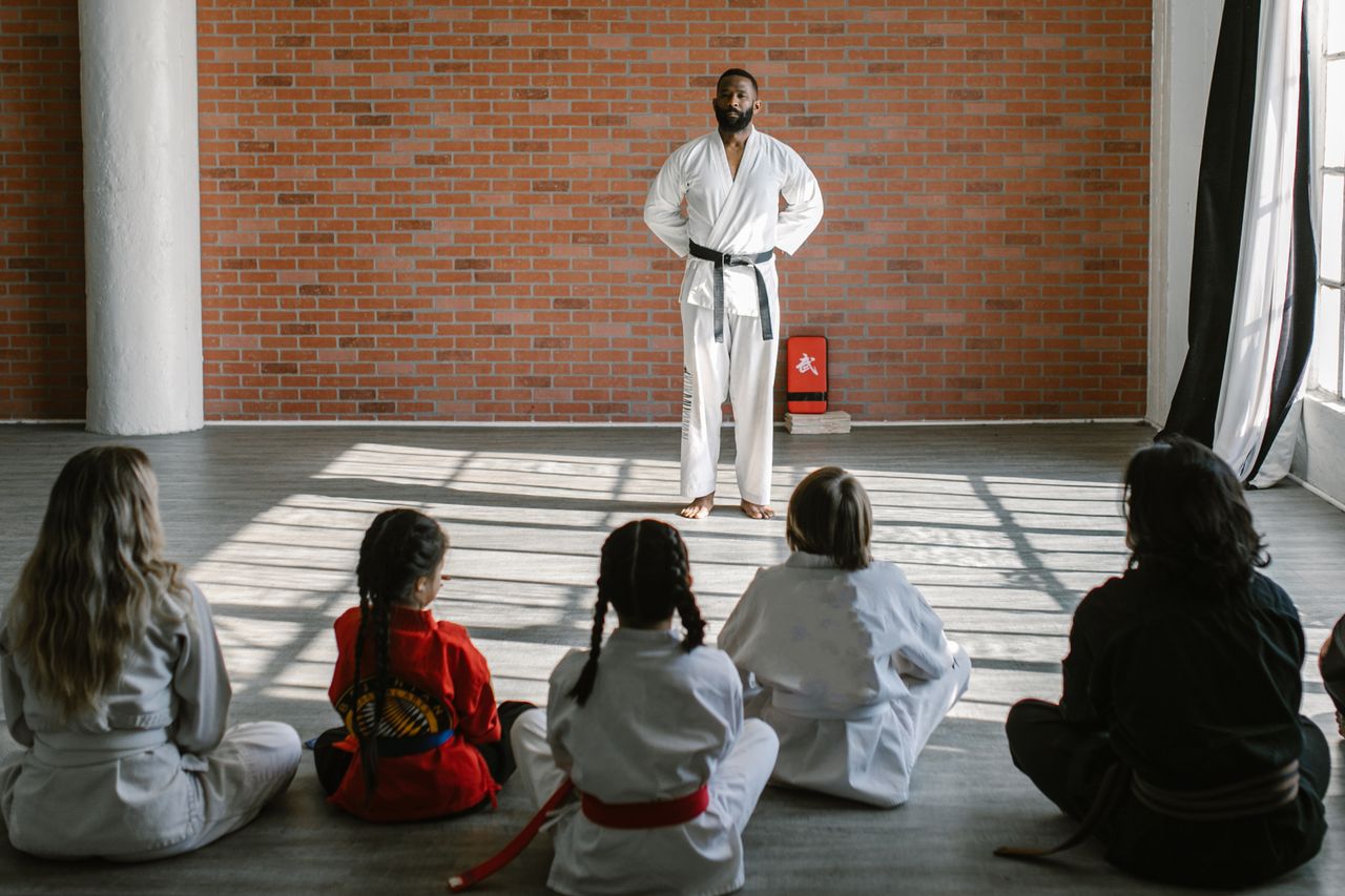 Crafting Captivating Headlines: Your awesome post title goes here Young students in gis learn martial arts under the guidance of a black belt sensei in a dojo setting.